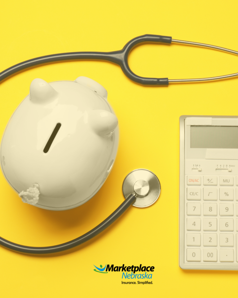 Overhead shot of a piggy bank, calculator, and a stethoscope